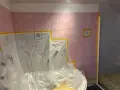 Badezimmerfliesen werden für das Streichen in der Mietwohnung abgeklebt.