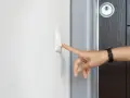 Finger drückt Klingelknopf. Das Hausrecht des Mieters wird durch das Betreten der Wohnung durch den Vermieter ohne Erlaubnis verletzt.