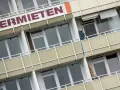 Fassade eines Mehrfamilienhauses mit der Aufschrift "ERMIETEN". Hier könnte man sich über den Mietspiegel Steinhagen informieren.