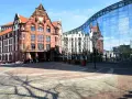 Historisches Gebäude und moderne Glasfassade spiegeln sich auf dem Platz. Hier könnte man sich über den Mietspiegel Dortmund informieren.
