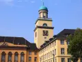 Gelber Turm mit Uhr und historischen Gebäuden in Witten. Die Immobilienpreise in Witten sind hier ein Thema.