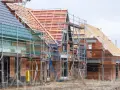 Neubau-Reihenhäuser in Moers im Rohbau, Gerüste umgeben die Ziegelbauten. Die steigenden immobilienpreise moers spiegeln sich in solchen Projekten wider.