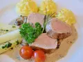 Zartes Schweinefilet mit Kartoffelröschen, Spargel und einer cremigen Sauce, serviert wie in einer alten Dorfbrennerei.