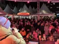 Menschenmenge auf dem Castrop Rauxel Weihnachtsmarkt vor der Dorfkneipe, eine Frau singt ins Mikrofon.