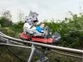 Junge mit Schneeleoparden-Maskottchen auf der Sommerrodelbahn Bottrop.