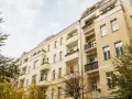 Gelbe Mehrfamilienhäuser mit Balkonen und Bäumen im Herbst. Ein Blick auf die Mietpreise im Rhein-Sieg-Kreis.