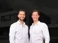 Zwei Männer vor einem modernen Haus. Sie sind Experten für Immobilienpreise in Korschenbroich und helfen Ihnen gerne weiter.
