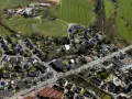 Luftaufnahme eines Dorfes mit Häusern, Straßen und Feldern.