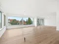 Helles, geräumiges Wohnzimmer mit großen Fenstern und Holzboden. Ideal, wenn Sie ein Mehrfamilienhaus verkaufen möchten.