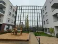 Moderne Wohnanlage mit Spielplatz und Sandkasten. Die Fassaden und Balkone sind hellgrau. Die Immobilienpreise in Leverkusen spiegeln die Attraktivität der Stadt wider.