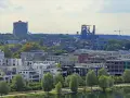 Moderne Wohngebäude am Wasser, im Hintergrund Industriedenkmäler und eine Kirche. Der Wohnungsmarkt Dortmund zeigt sich hier von seiner modernen Seite.