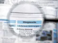 Lupe über Zeitungsanzeigen mit "Mietgesuche" und "2-Zimmer-Wohnungen". Ein Blick auf den Mietspiegel Moers.