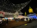 Glitzernde Lichterketten schmücken den **Weihnachtsmarkt in Dorsten**. Menschen bummeln unter Zelten und vor Buden, während im Hintergrund die beleuchtete Kirche thront.