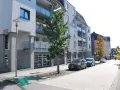 Moderne Wohngebäude mit Balkonen und Autos auf der Straße. Ein Baum steht vor einem Gebäude. Informationen zum Mietspiegel Wermelskirchen sind hier nicht ersichtlich.