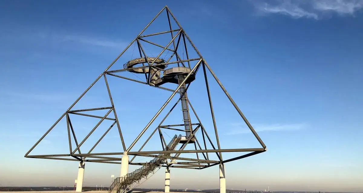Das Tetraeder auf der Halde Beckstraße in Bottrop, ein Wahrzeichen der Industriekultur, ragt gegen einen blauen Himmel.