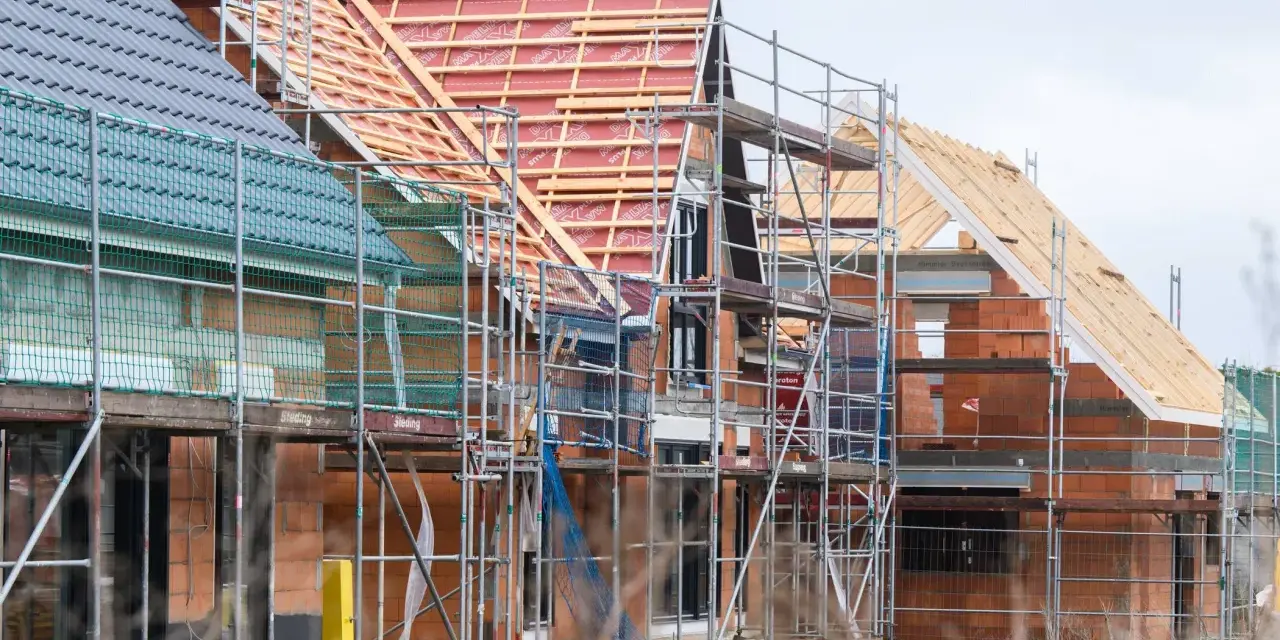 Neubau-Reihenhäuser in Moers im Rohbau, Gerüste umgeben die Ziegelbauten. Die steigenden immobilienpreise moers spiegeln sich in solchen Projekten wider.