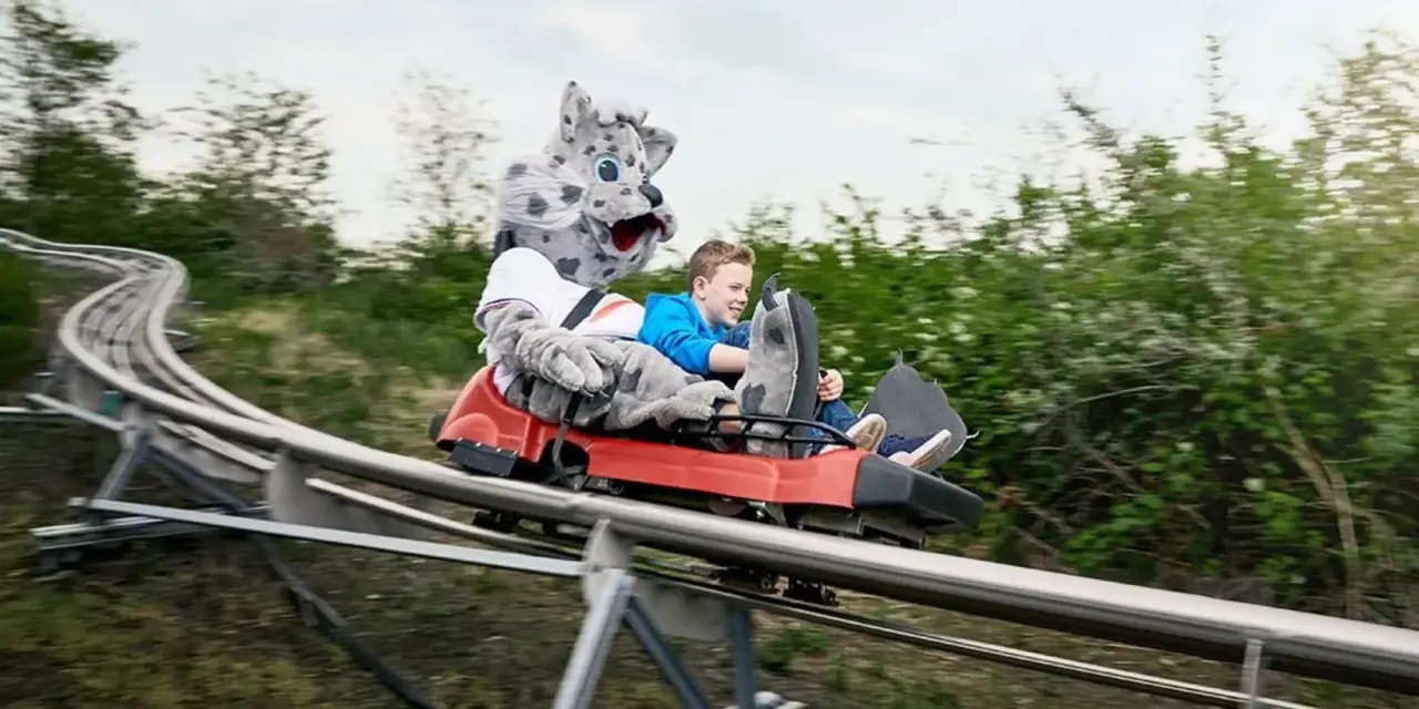 Junge mit Schneeleoparden-Maskottchen auf der Sommerrodelbahn Bottrop.