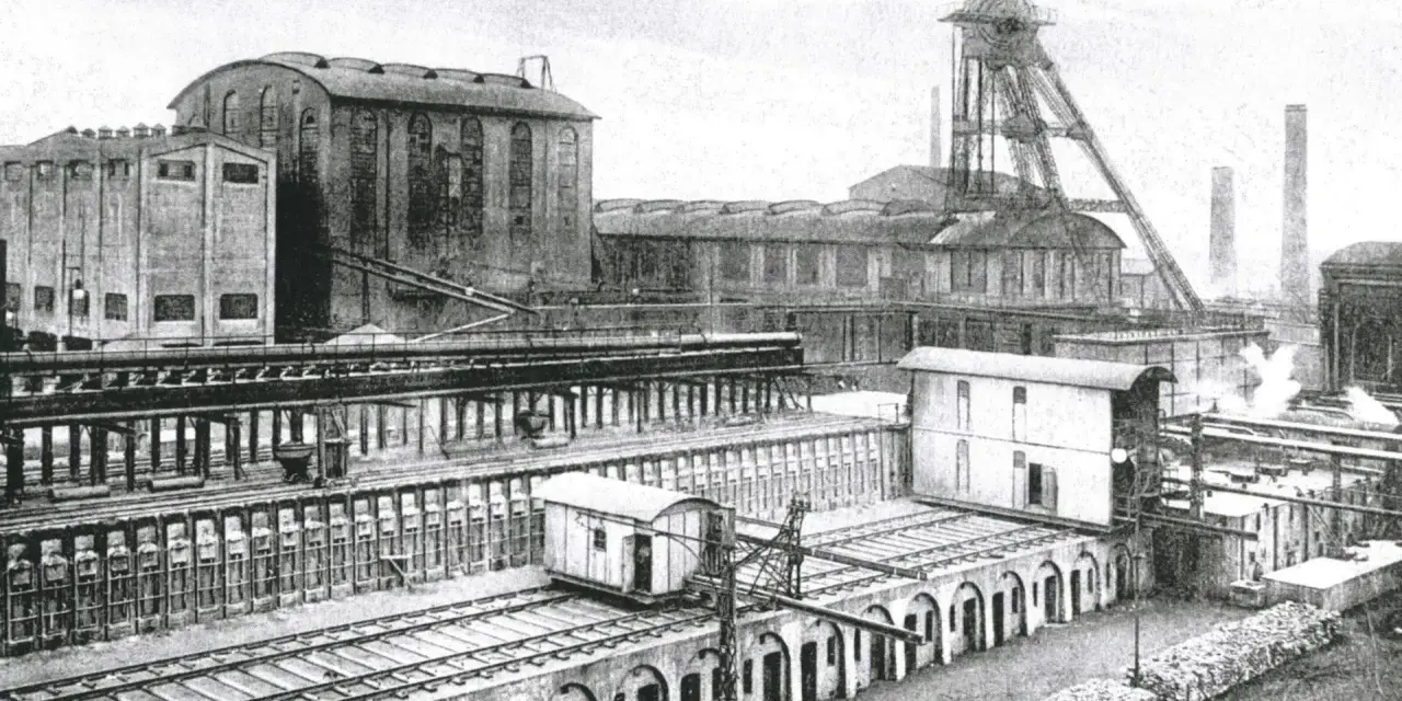 Industriekomplex Zeche Recklinghausen Hochlarmark mit Förderturm, Gebäuden und Bahngleisen.
