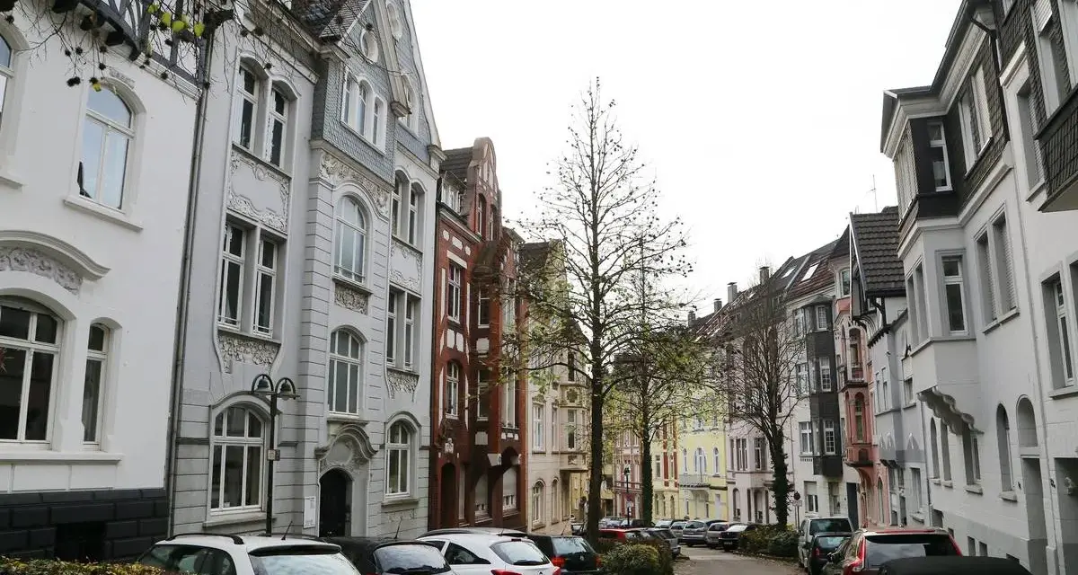 Reihenhäuser in Solingen, die einen Eindruck vom Mietspiegel vermitteln. Autos parken in der Straße.