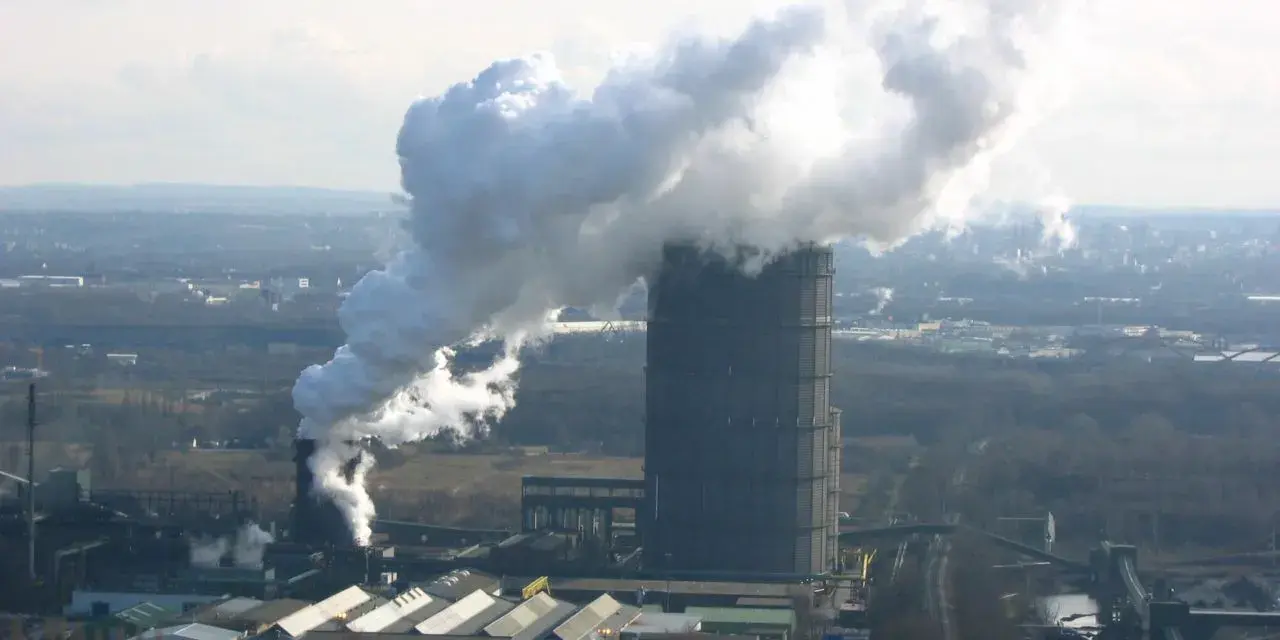 Rauch steigt aus dem hohen Turm der Kokerei Bottrop auf. Die Schließung dieser Industrieanlage markiert das Ende einer Ära.