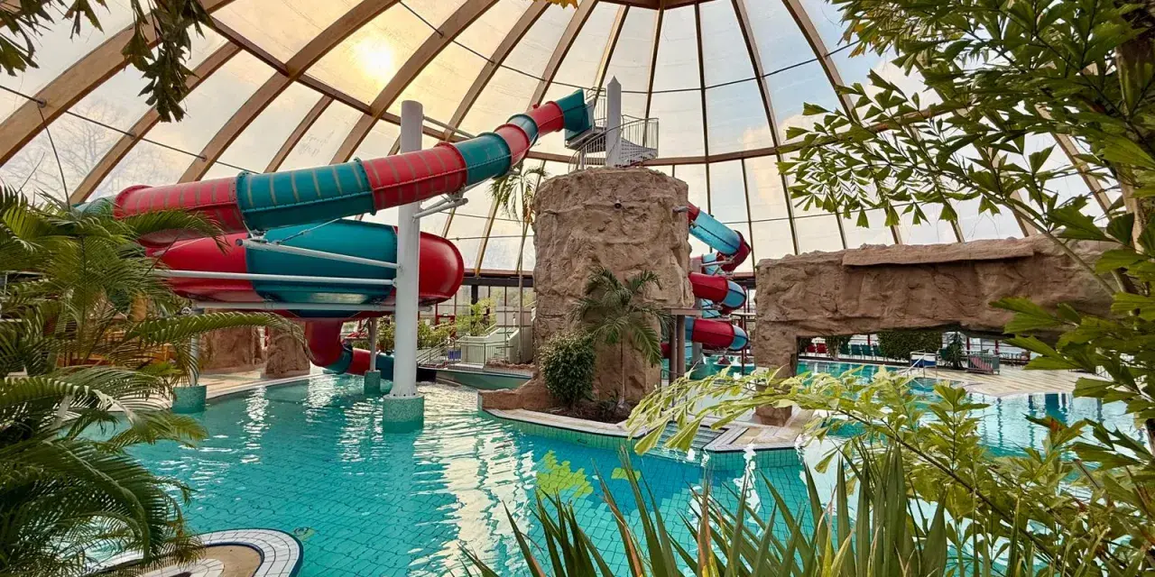 Buntes Rutschenparadies im **Dorsten Freibad** unter einem Glasdach. Türkises Wasser lädt zum Planschen ein.