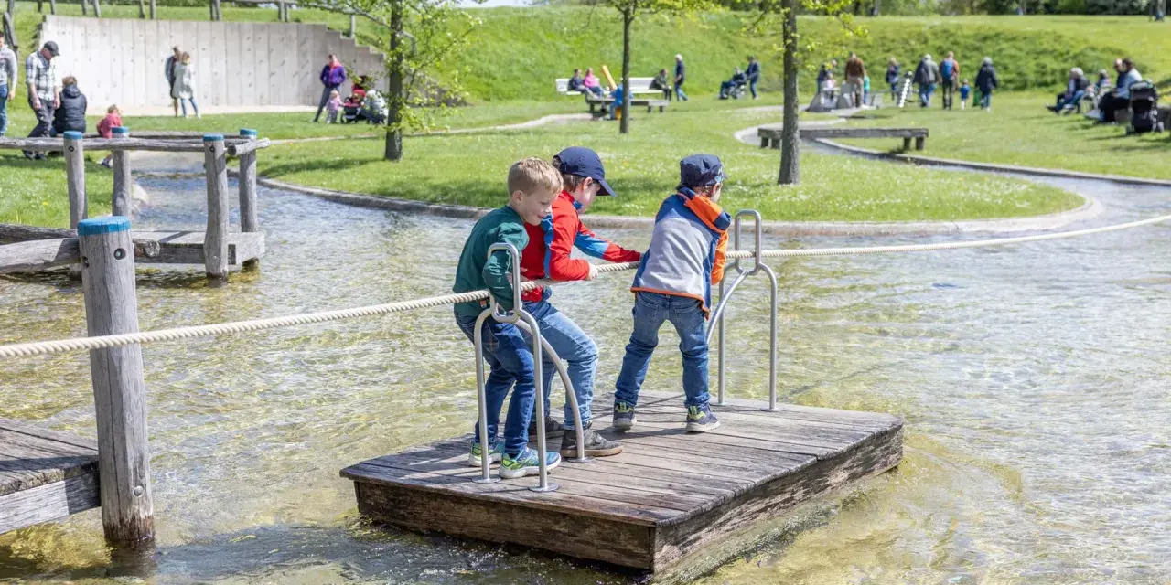 Drei Jungen auf einem Floß im Wasserpark am Schiffshebewerk Henrichenburg. Ein Spielplatz für kleine Abenteurer.