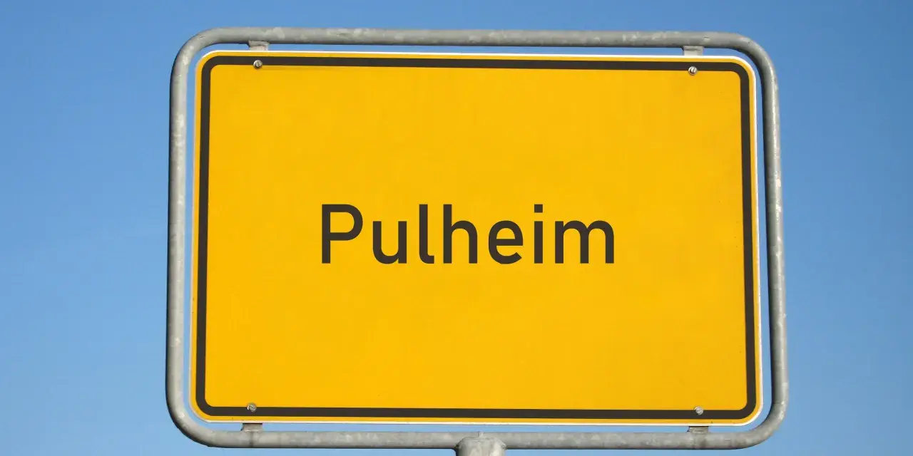 Ortsschild "Pulheim" vor blauem Himmel. Hier finden Sie Informationen zum Mietspiegel Pulheim.