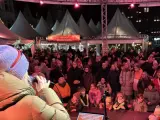 Menschenmenge auf dem Castrop Rauxel Weihnachtsmarkt vor der Dorfkneipe, eine Frau singt ins Mikrofon.