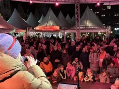 Menschenmenge auf dem Castrop Rauxel Weihnachtsmarkt vor der Dorfkneipe, eine Frau singt ins Mikrofon.