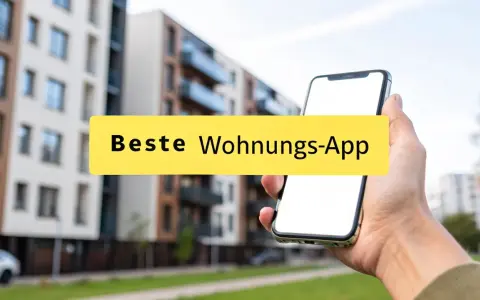 Hand hält Smartphone mit der Aufschrift "Beste Wohnungs-App" vor modernen Gebäuden.