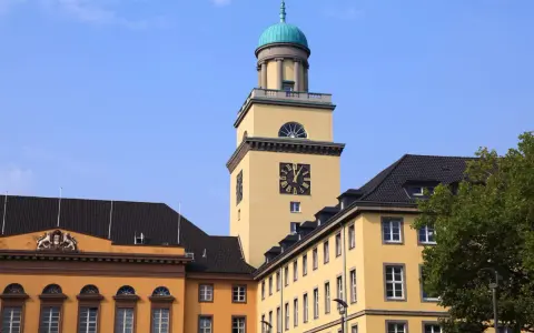 Gelber Turm mit Uhr und historischen Gebäuden in Witten. Die Immobilienpreise in Witten sind hier ein Thema.