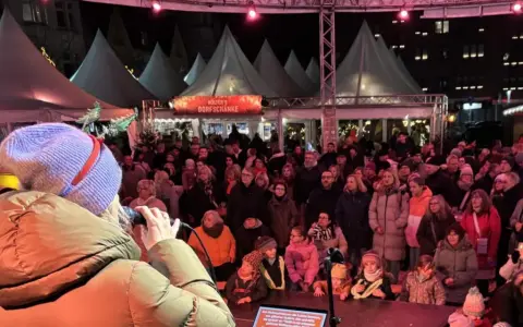 Menschenmenge auf dem Castrop Rauxel Weihnachtsmarkt vor der Dorfkneipe, eine Frau singt ins Mikrofon.