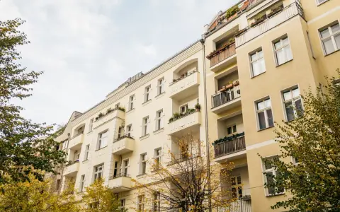 Gelbe Mehrfamilienhäuser mit Balkonen und Bäumen im Herbst. Ein Blick auf die Mietpreise im Rhein-Sieg-Kreis.