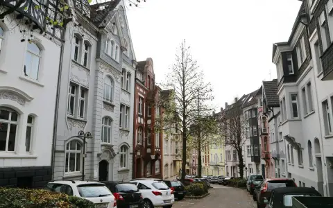 Reihenhäuser in Solingen, die einen Eindruck vom Mietspiegel vermitteln. Autos parken in der Straße.