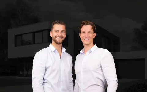 Zwei Männer vor einem modernen Haus. Sie sind Experten für Immobilienpreise in Korschenbroich und helfen Ihnen gerne weiter.