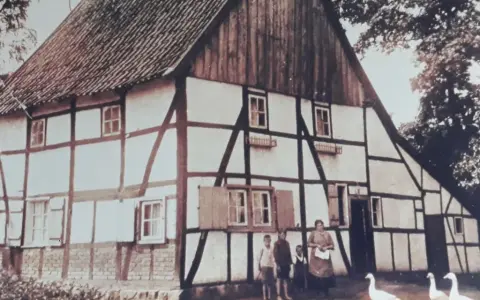 Fachwerkhaus in Lohburg, Waltrop, mit Familie und Gänsen vor dem Haus.
