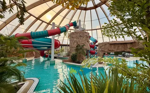 Buntes Rutschenparadies im **Dorsten Freibad** unter einem Glasdach. Türkises Wasser lädt zum Planschen ein.