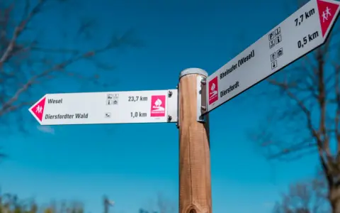 Wegweiser mit Zielen wie Wesel, Diersfordter Wald und Rheinufer (Wesel). Die hohe Mark steig ist gut sichtbar.