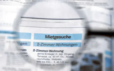 Lupe über Zeitungsanzeigen mit "Mietgesuche" und "2-Zimmer-Wohnungen". Ein Blick auf den Mietspiegel Moers.