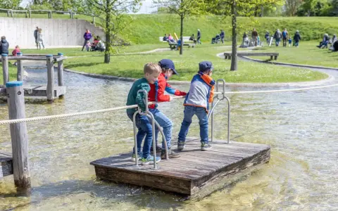 Drei Jungen auf einem Floß im Wasserpark am Schiffshebewerk Henrichenburg. Ein Spielplatz für kleine Abenteurer.