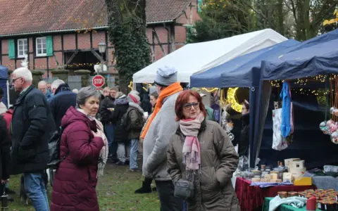 Besucher genießen den Herten Weihnachtsmarkt mit Ständen, Lichtern und festlicher Atmosphäre.