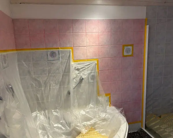 Badezimmerfliesen werden für das Streichen in der Mietwohnung abgeklebt.