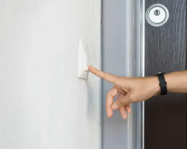 Finger drückt Klingelknopf. Das Hausrecht des Mieters wird durch das Betreten der Wohnung durch den Vermieter ohne Erlaubnis verletzt.
