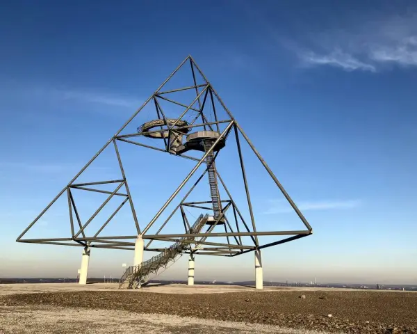 Das Tetraeder auf der Halde Beckstraße in Bottrop, ein Wahrzeichen der Industriekultur, ragt gegen einen blauen Himmel.