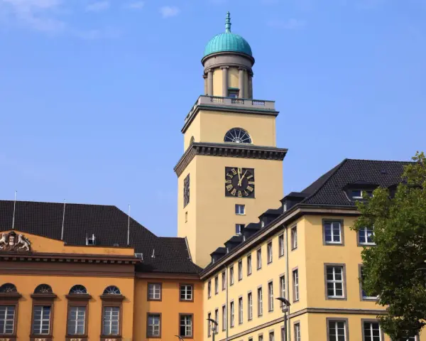 Gelber Turm mit Uhr und historischen Gebäuden in Witten. Die Immobilienpreise in Witten sind hier ein Thema.