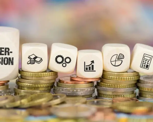 Holzwürfel mit "Makler-Provision" und Symbolen für Geld, Zahnräder, Wachstum, Diagramm, Rechner und Waage auf Münzstapeln. Ein nachweismakler und vermittlungsmakler verstehen diese Symbole.