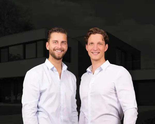 Zwei Männer vor einem modernen Haus. Sie sind Experten für Immobilienpreise in Korschenbroich und helfen Ihnen gerne weiter.
