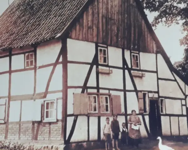 Fachwerkhaus in Lohburg, Waltrop, mit Familie und Gänsen vor dem Haus.