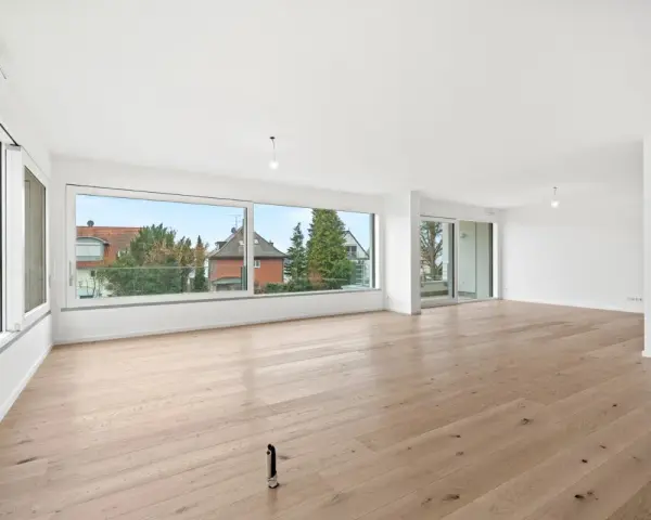 Helles, geräumiges Wohnzimmer mit großen Fenstern und Holzboden. Ideal, wenn Sie ein Mehrfamilienhaus verkaufen möchten.