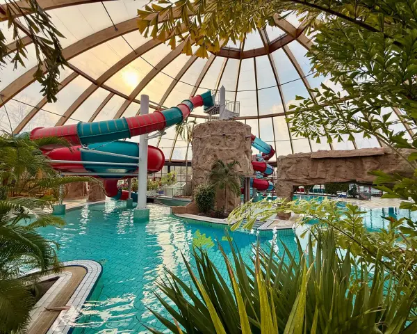 Buntes Rutschenparadies im **Dorsten Freibad** unter einem Glasdach. Türkises Wasser lädt zum Planschen ein.
